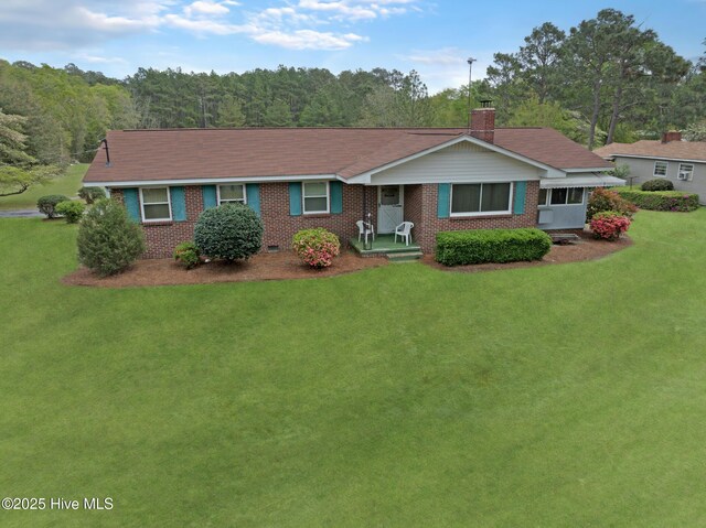 377 Louis Breeden Blvd, Hamlet, NC 28345 - ranch-style home featuring a front yard, a chimney, brick siding, and a wooded view