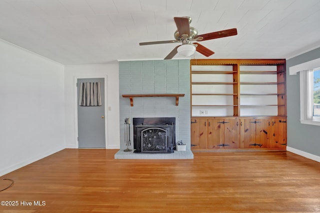 377 Louis Breeden Blvd, Hamlet, NC 28345 - unfurnished living room with wood finished floors, a ceiling fan, and a fireplace
