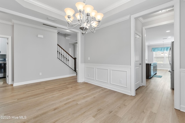 2955 Moorings Way SE, Southport, NC 28461 - spare room with a chandelier, light wood finished floors, stairway, and ornamental molding