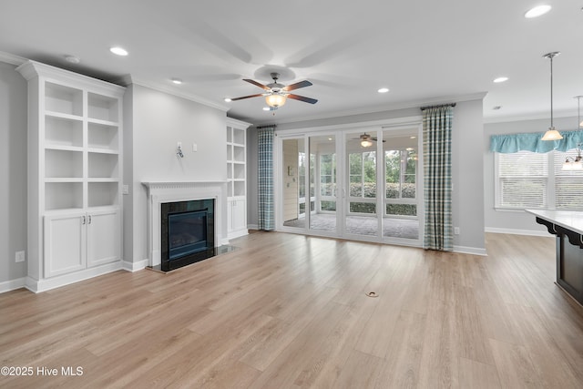2955 Moorings Way SE, Southport, NC 28461 - unfurnished living room with a ceiling fan, crown molding, a premium fireplace, light wood-type flooring, and built in shelves