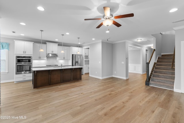 2955 Moorings Way SE, Southport, NC 28461 - kitchen featuring crown molding, stainless steel appliances, ceiling fan, under cabinet range hood, and light countertops