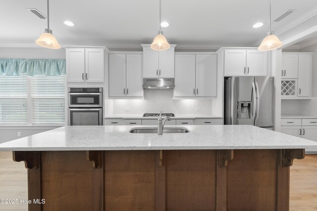 2955 Moorings Way SE, Southport, NC 28461 - kitchen with stainless steel appliances, crown molding, white cabinetry, a kitchen breakfast bar, and tasteful backsplash