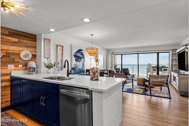 8801 Reed Dr Unit 303W, Emerald Isle, NC 28594 - kitchen featuring stainless steel dishwasher, blue cabinets, wood walls, light wood-type flooring, and light countertops