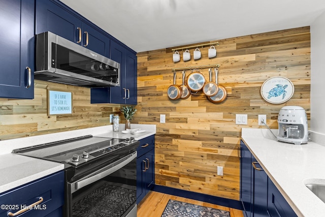 8801 Reed Dr Unit 303W, Emerald Isle, NC 28594 - kitchen featuring electric range, stainless steel microwave, blue cabinetry, and wood walls