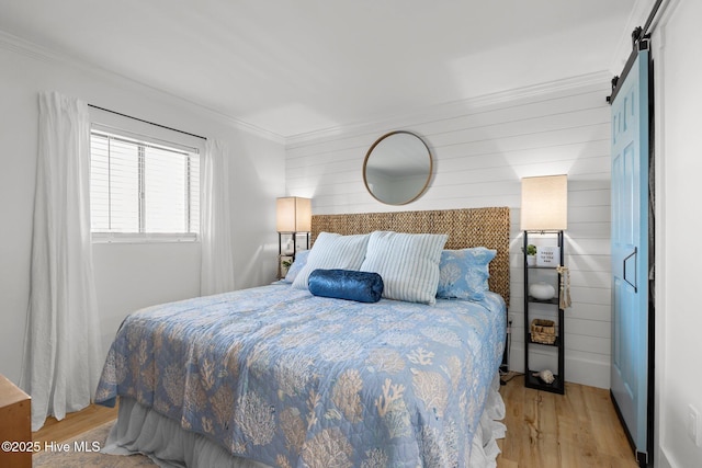 8801 Reed Dr Unit 303W, Emerald Isle, NC 28594 - bedroom with wood finished floors, a barn door, and ornamental molding