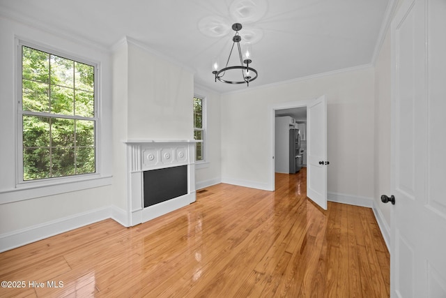 25967 US-264, Pantego, NC 27860 - unfurnished living room with a chandelier, crown molding, a fireplace, and light wood finished floors