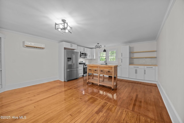 25967 US-264, Pantego, NC 27860 - kitchen featuring appliances with stainless steel finishes, backsplash, ornamental molding, an AC wall unit, and white cabinetry