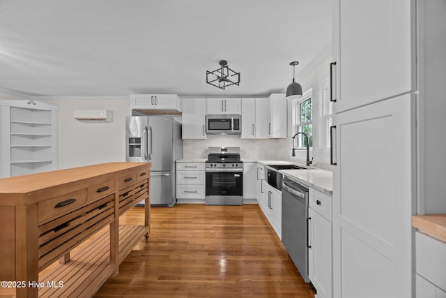 25967 US-264, Pantego, NC 27860 - kitchen featuring stainless steel appliances, wood finished floors, white cabinetry, pendant lighting, and tasteful backsplash
