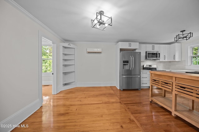 25967 US-264, Pantego, NC 27860 - kitchen with appliances with stainless steel finishes, white cabinets, light wood-type flooring, crown molding, and backsplash