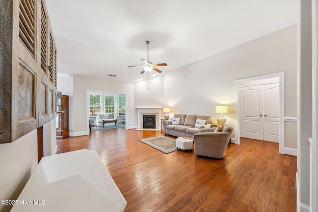 3716 Pond Pine Ct, Southport, NC 28461 - living room featuring a glass covered fireplace, ceiling fan, wood finished floors, and ornamental molding
