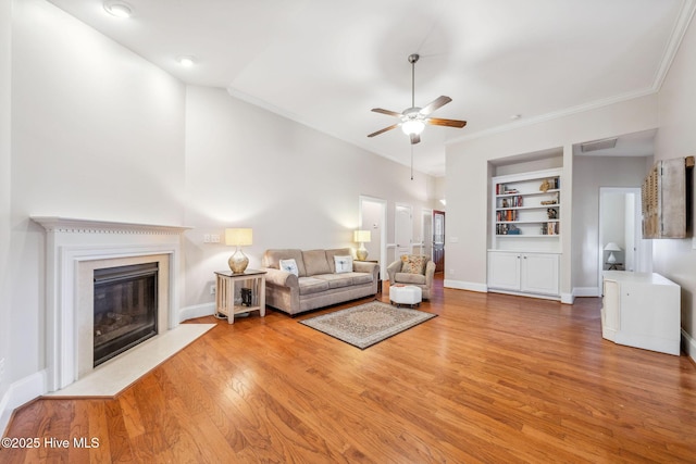 3716 Pond Pine Ct, Southport, NC 28461 - living room featuring a ceiling fan, wood finished floors, crown molding, a high end fireplace, and built in features