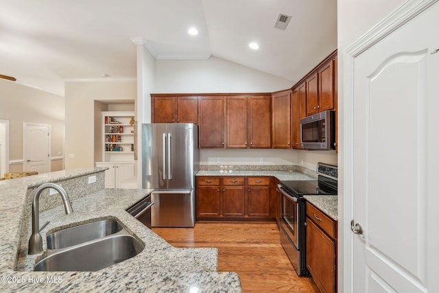 3716 Pond Pine Ct, Southport, NC 28461 - kitchen featuring appliances with stainless steel finishes, light wood-type flooring, ornamental molding, light stone countertops, and lofted ceiling