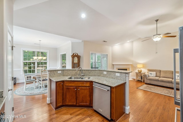 3716 Pond Pine Ct, Southport, NC 28461 - kitchen with stainless steel dishwasher, brown cabinets, light wood-style flooring, a chandelier, and light stone countertops