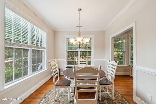 3716 Pond Pine Ct, Southport, NC 28461 - dining space with a chandelier, wood finished floors, and crown molding