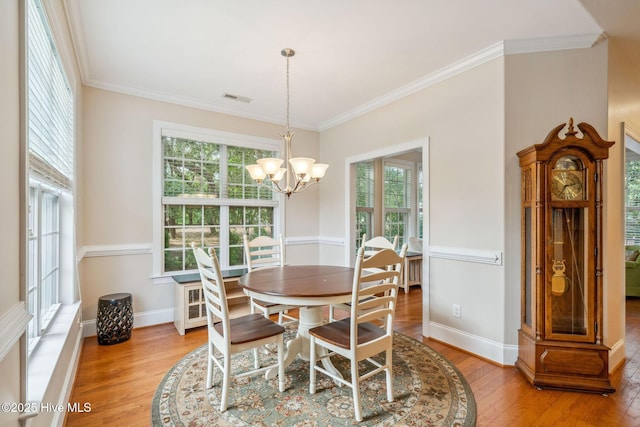 3716 Pond Pine Ct, Southport, NC 28461 - dining room with light wood-type flooring, healthy amount of natural light, ornamental molding, and a chandelier