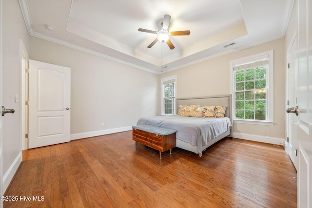 3716 Pond Pine Ct, Southport, NC 28461 - bedroom featuring a tray ceiling, wood finished floors, ornamental molding, and a ceiling fan