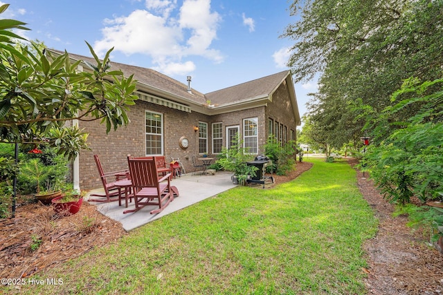 3716 Pond Pine Ct, Southport, NC 28461 - back of house with a patio, brick siding, a lawn, and a shingled roof