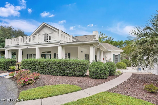 3716 Pond Pine Ct, Southport, NC 28461 - view of front of house with a balcony, a chimney, and roof with shingles