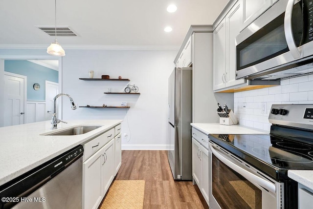 1022 Summer Woods Dr, Wilmington, NC 28412 - kitchen with appliances with stainless steel finishes, crown molding, light countertops, backsplash, and pendant lighting