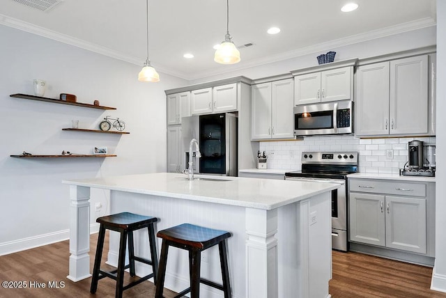 1022 Summer Woods Dr, Wilmington, NC 28412 - kitchen featuring stainless steel appliances, gray cabinetry, a kitchen bar, dark wood-style flooring, and light countertops