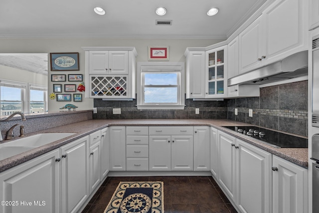 120 Windjammer Dr, Surf City, NC 28445 - kitchen with black electric cooktop, healthy amount of natural light, white cabinetry, glass insert cabinets, and ornamental molding