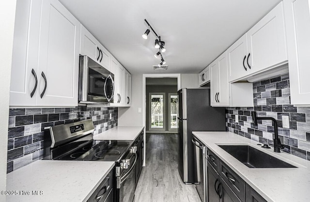 130 Salter Path Rd Unit 74, Pine Knoll Shores, NC 28512 - kitchen featuring stainless steel appliances, white cabinetry, light stone counters, light wood-type flooring, and dark cabinetry
