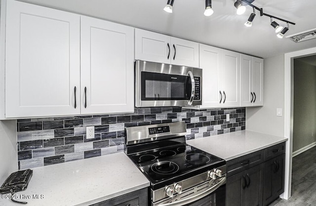 130 Salter Path Rd Unit 74, Pine Knoll Shores, NC 28512 - kitchen featuring stainless steel appliances, white cabinets, tasteful backsplash, light wood finished floors, and dark cabinets