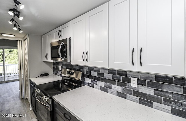130 Salter Path Rd Unit 74, Pine Knoll Shores, NC 28512 - kitchen with stainless steel appliances, light stone counters, tasteful backsplash, and white cabinets