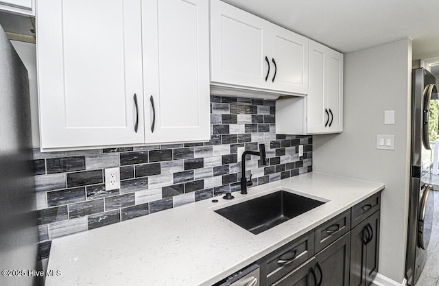130 Salter Path Rd Unit 74, Pine Knoll Shores, NC 28512 - kitchen with white cabinets, light stone countertops, tasteful backsplash, and fridge