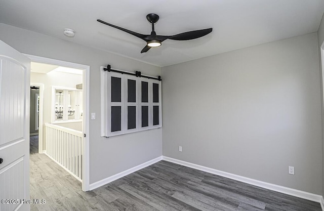 130 Salter Path Rd Unit 74, Pine Knoll Shores, NC 28512 - spare room featuring ceiling fan, wood finished floors, a barn door, and a smoke detector