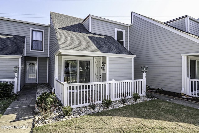 130 Salter Path Rd Unit 74, Pine Knoll Shores, NC 28512 - view of front of property featuring roof with shingles, a front yard, and covered porch