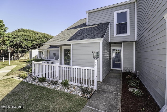130 Salter Path Rd Unit 74, Pine Knoll Shores, NC 28512 - view of exterior entry with a shingled roof and a lawn