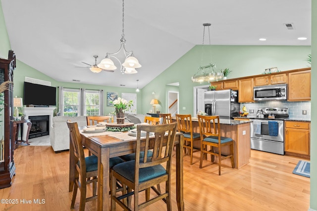 133 Graystone Rd, Wilmington, NC 28411 - dining space with a chandelier, lofted ceiling, light wood-style floors, and a fireplace