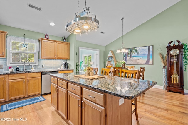 133 Graystone Rd, Wilmington, NC 28411 - kitchen featuring dishwasher, a breakfast bar, lofted ceiling, light wood-style floors, and tasteful backsplash