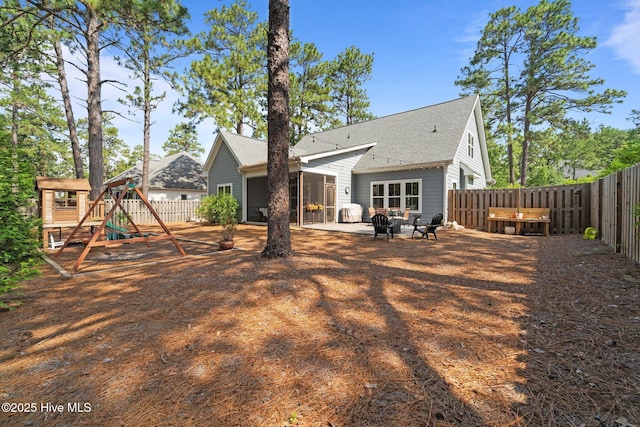 3 Glen Ross Dr, Pinehurst, NC 28374 - back of property with a playground, a fenced backyard, a sunroom, and roof with shingles