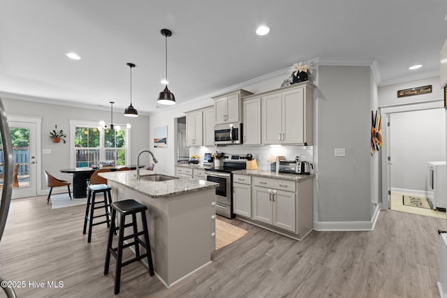 3 Glen Ross Dr, Pinehurst, NC 28374 - kitchen featuring appliances with stainless steel finishes, crown molding, separate washer and dryer, light wood finished floors, and a center island with sink