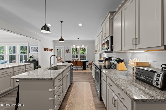 3 Glen Ross Dr, Pinehurst, NC 28374 - kitchen with stainless steel appliances, a kitchen island with sink, healthy amount of natural light, dark wood-style flooring, and ornamental molding