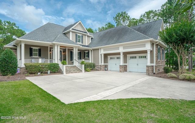 595 Wicklow Sq SW, Ocean Isle Beach, NC 28469 - craftsman-style home with covered porch, a garage, concrete driveway, a front yard, and stone siding