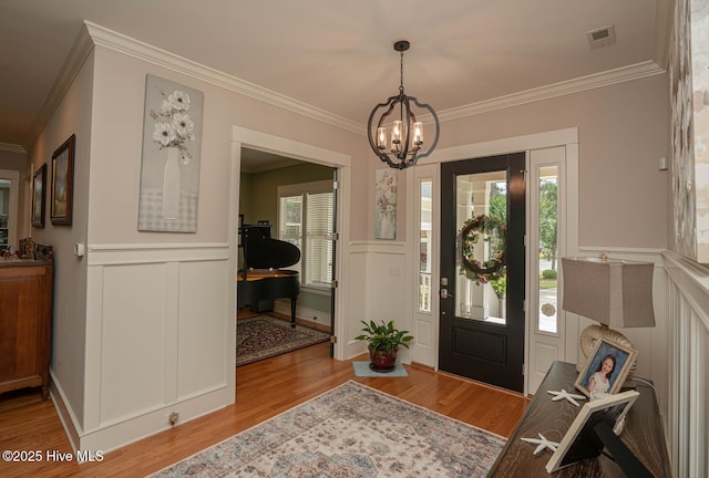 595 Wicklow Sq SW, Ocean Isle Beach, NC 28469 - foyer entrance featuring a chandelier, ornamental molding, wood finished floors, plenty of natural light, and a decorative wall