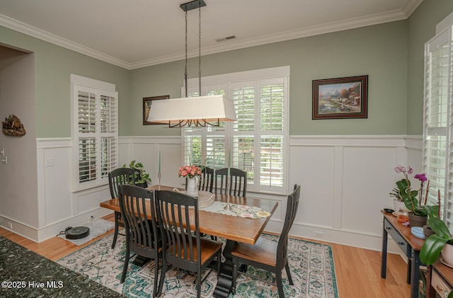 595 Wicklow Sq SW, Ocean Isle Beach, NC 28469 - dining area featuring crown molding, wood finished floors, a decorative wall, and a wainscoted wall
