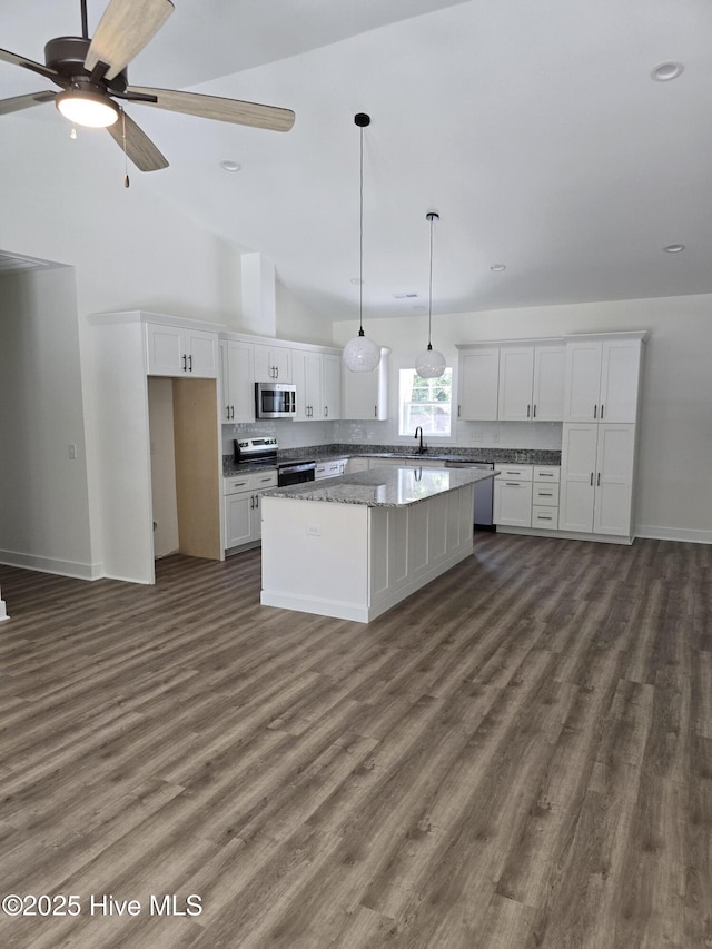 904 Nautillus Ct, New Bern, NC 28560 - kitchen featuring appliances with stainless steel finishes, white cabinets, a center island, dark wood-style floors, and tasteful backsplash