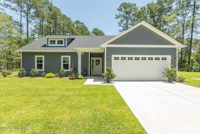 430 Boundaryline Dr NW, Calabash, NC 28467 - view of front of house featuring a garage, a front lawn, driveway, a shingled roof, and board and batten siding