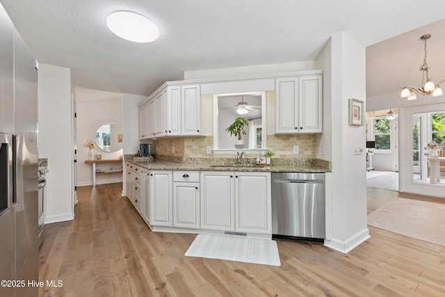 103 Coppers Trl, Wilmington, NC 28411 - kitchen with stainless steel dishwasher, decorative backsplash, a ceiling fan, light wood-style floors, and lofted ceiling
