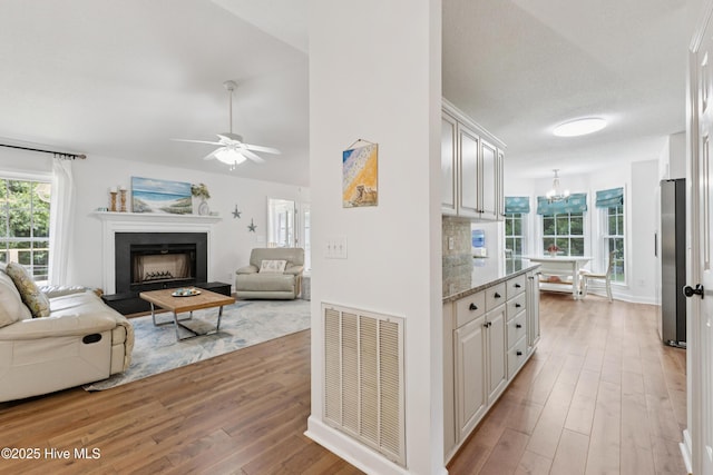 103 Coppers Trl, Wilmington, NC 28411 - kitchen with freestanding refrigerator, light wood-style floors, a chandelier, a fireplace with raised hearth, and white cabinets