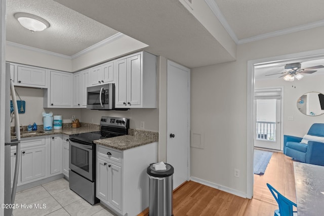 1004 Carolina Beach Ave S Unit B6, Carolina Beach, NC 28428 - kitchen with appliances with stainless steel finishes, a textured ceiling, light wood finished floors, ornamental molding, and a ceiling fan