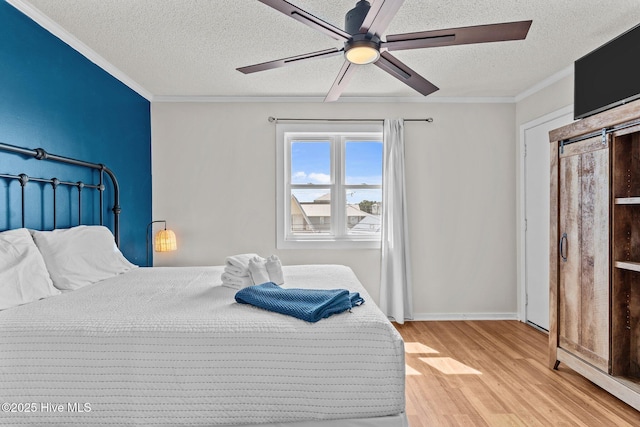 1004 Carolina Beach Ave S Unit B6, Carolina Beach, NC 28428 - bedroom featuring light wood finished floors, a textured ceiling, crown molding, and ceiling fan