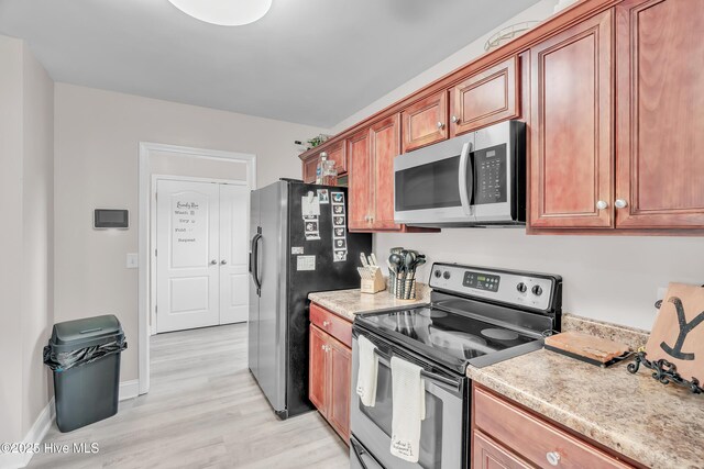 203 Mccain St, Beulaville, NC 28518 - kitchen with appliances with stainless steel finishes, light wood finished floors, light countertops, and brown cabinets