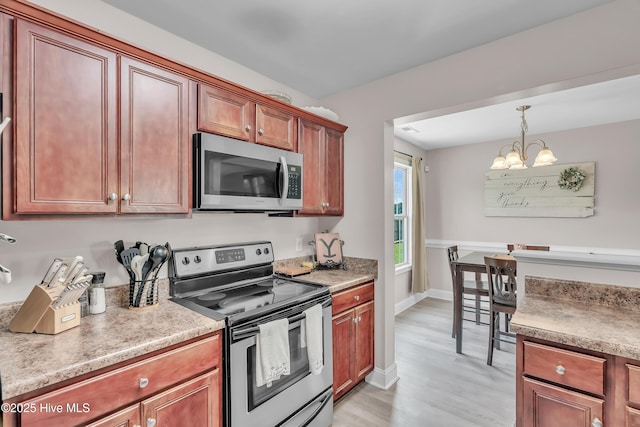 203 Mccain St, Beulaville, NC 28518 - kitchen with stainless steel appliances, a chandelier, light wood finished floors, hanging light fixtures, and light countertops