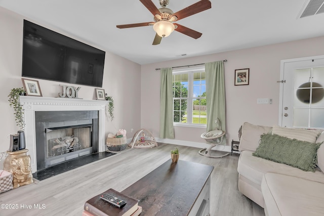 203 Mccain St, Beulaville, NC 28518 - living area with a ceiling fan, wood finished floors, and a fireplace with flush hearth