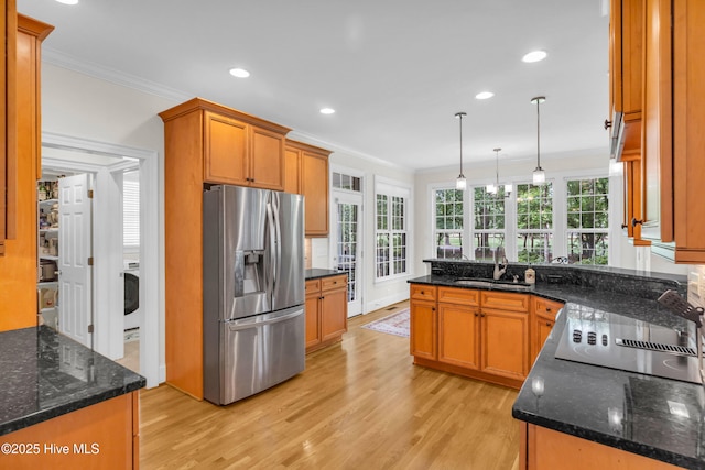 1514 Grandiflora Dr, Leland, NC 28451 - kitchen with stainless steel fridge with ice dispenser, crown molding, light wood-style floors, brown cabinetry, and hanging light fixtures